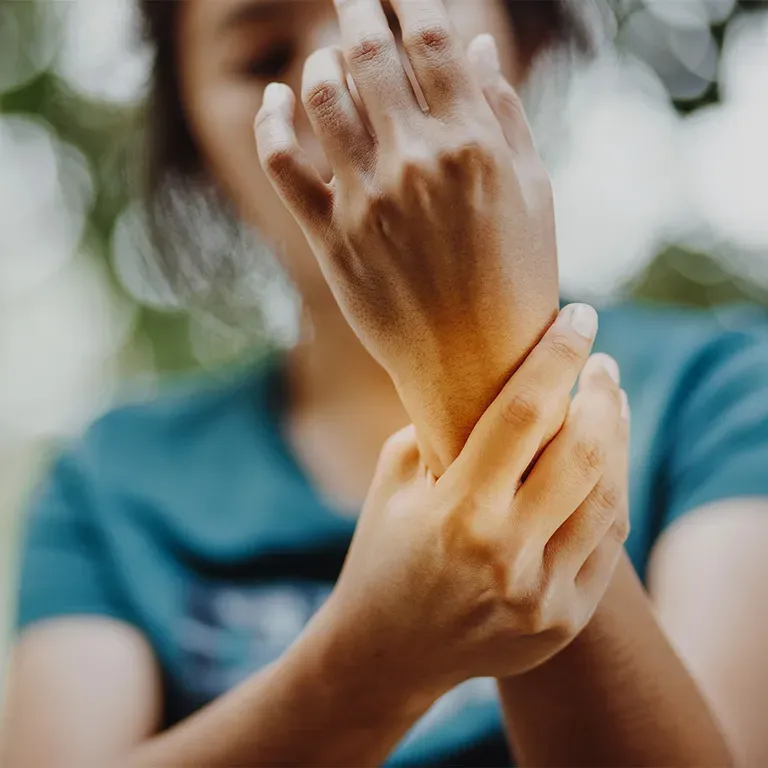 Woman holding her wrist.